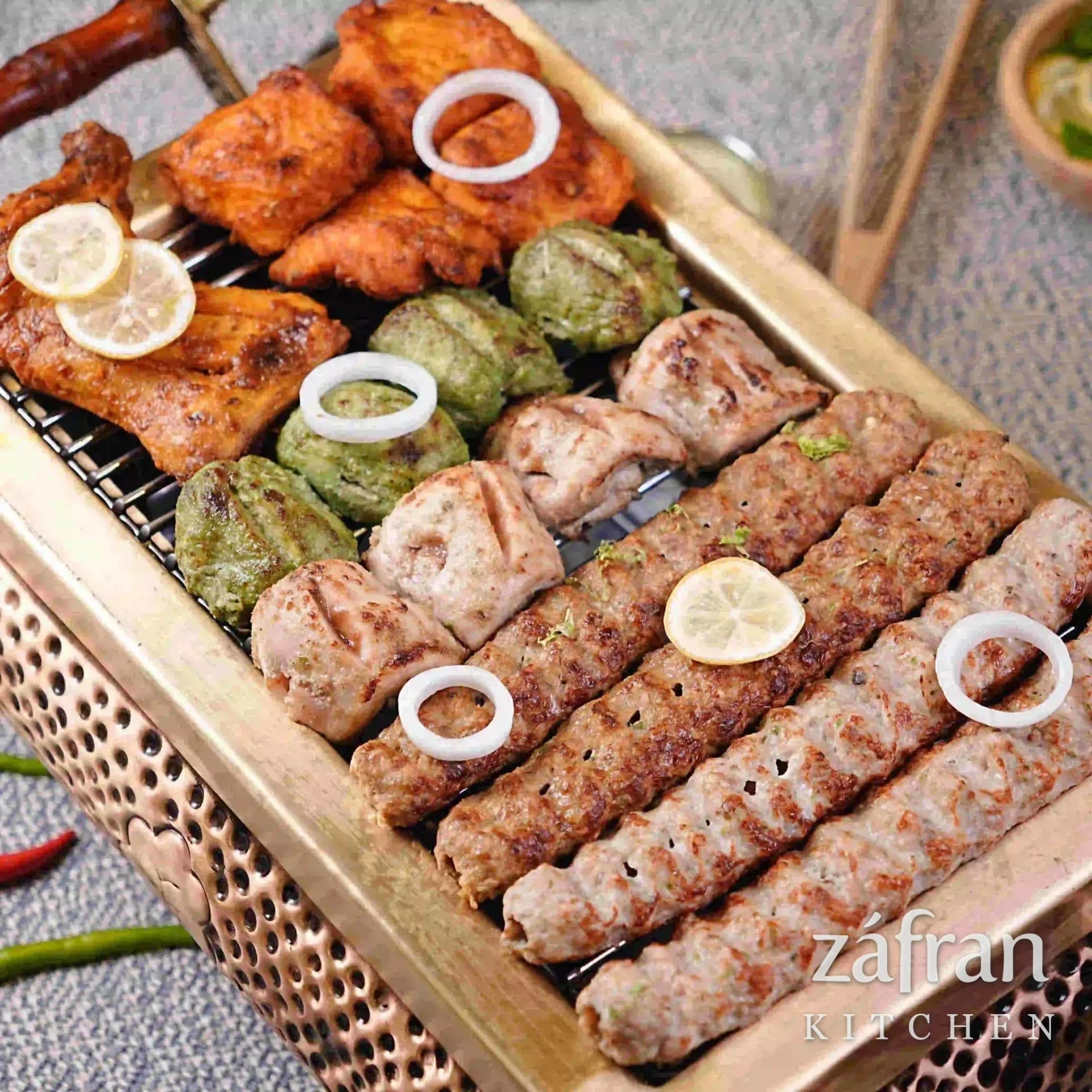 Seekh kababs and chicken boti turning over charcoal at Zafran Kitchen, Ajman Industrial Area 2