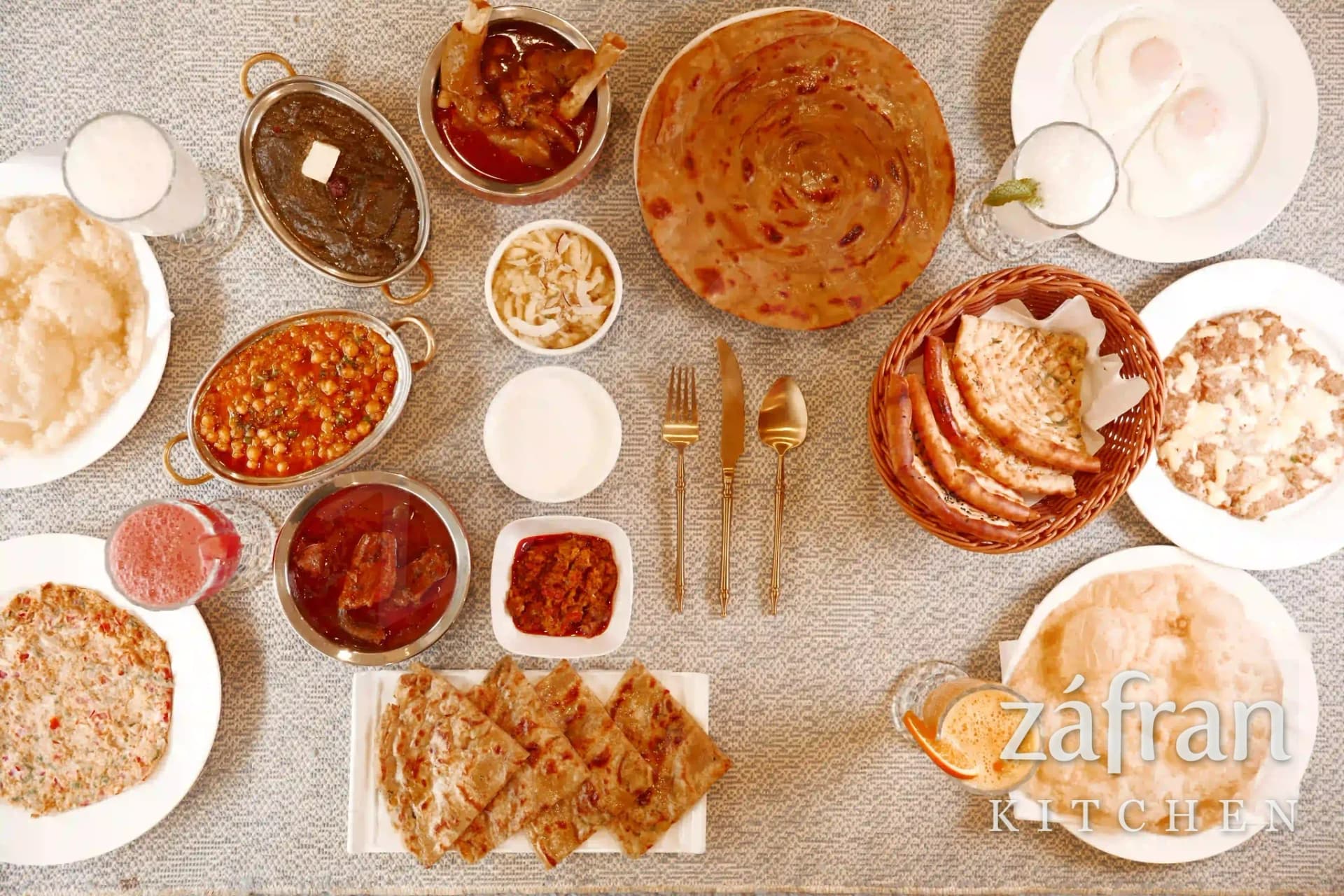 A full desi nashta spread of paratha, chana, paya, nihari and chai at Zafran Kitchen Ajman