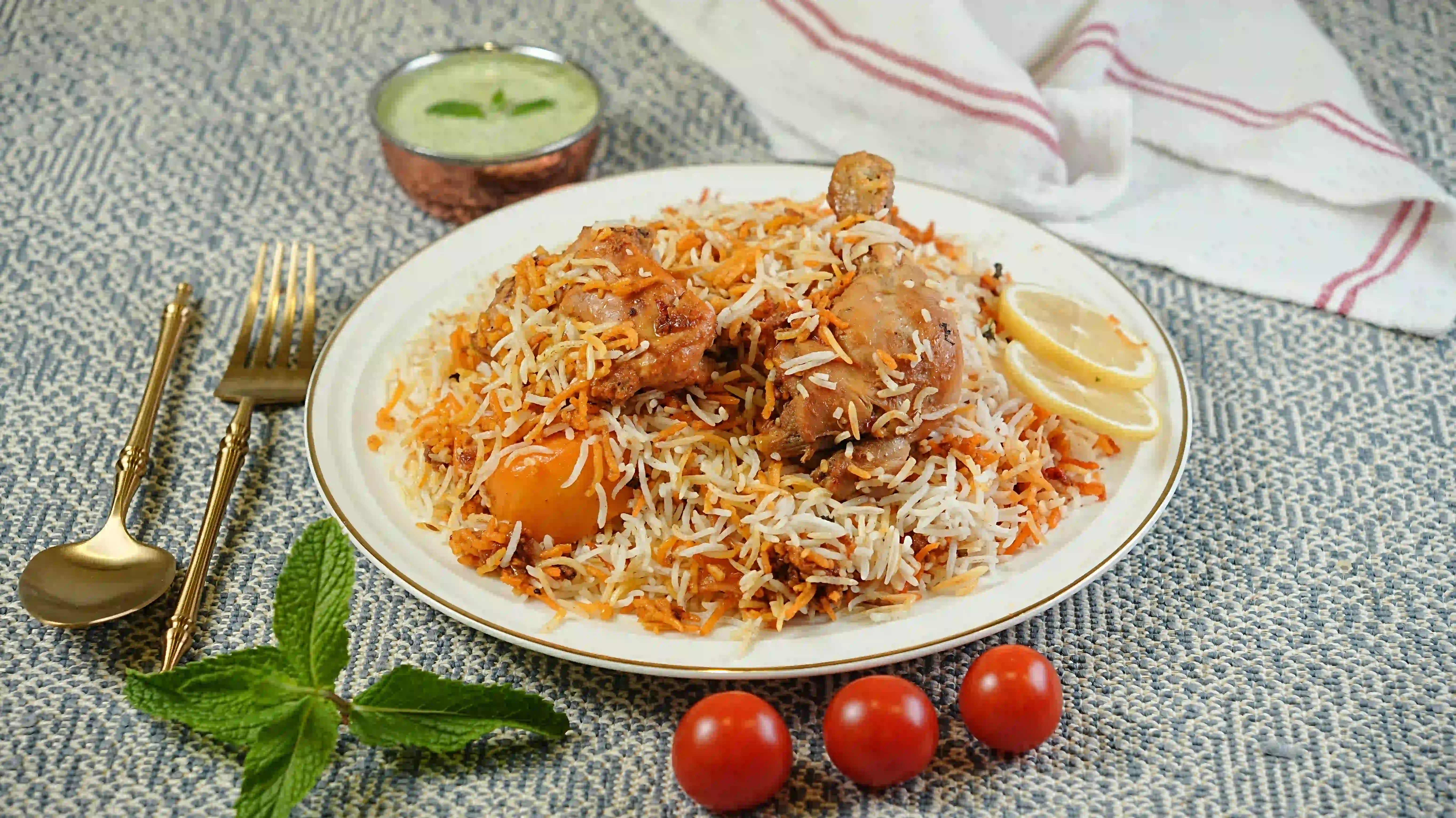 Plate of chicken biryani with raita at Zafran Kitchen, Ajman Industrial Area 2