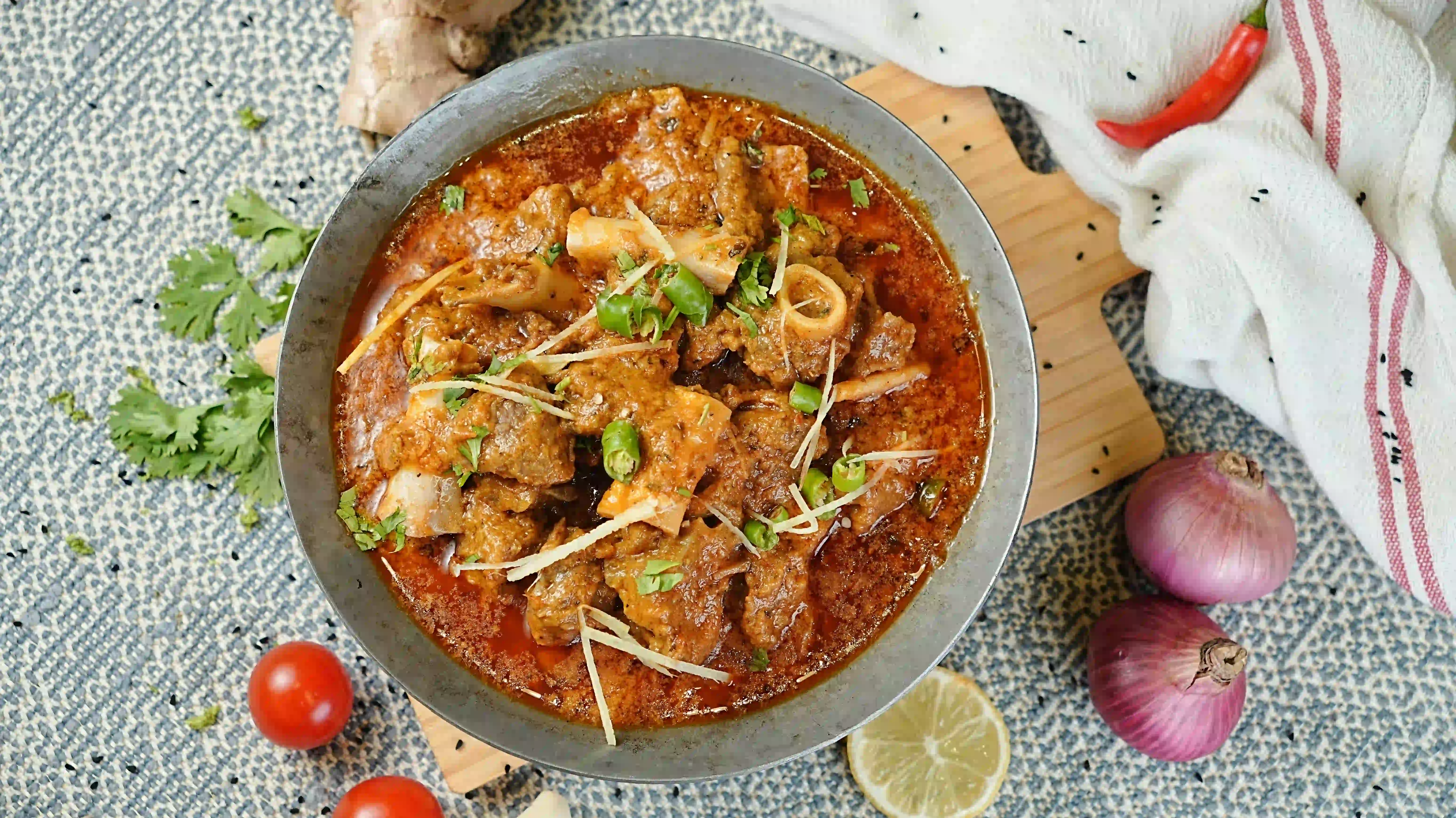 Karahi cooking over an open flame in the kitchen at Zafran Kitchen, Ajman