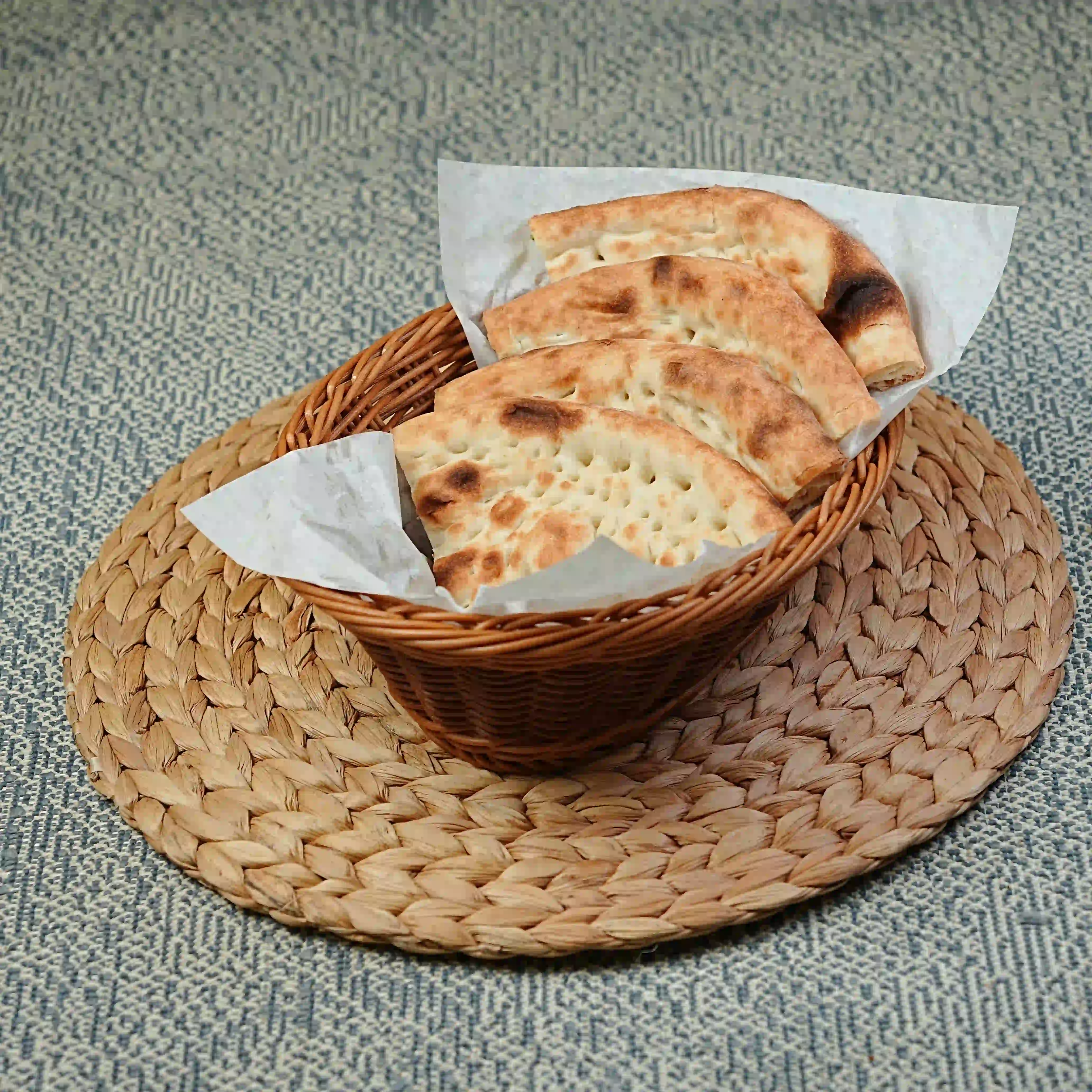 Plain tandoori naan served warm in a basket at Zafran Kitchen, Ajman